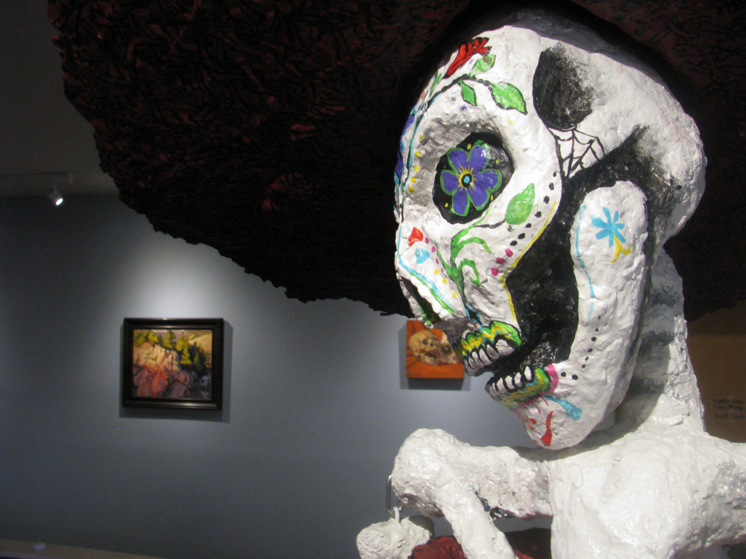 An image of a paper mache skull with Day of the Dead artwork painted on, from the Silver City Museum's curated show called "Arte Chicano"