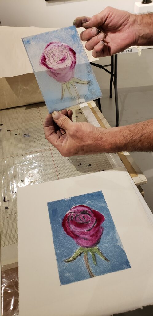 Closeup on a person's hands showing a print of a flower painting.